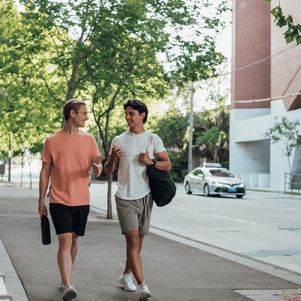 Two white men are talking and walking down the street